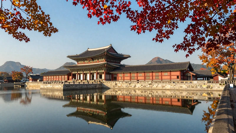Gyeongbokgung Palace in Seoul reflected in water surrounded by autumn foliage representing Korean cultural heritage