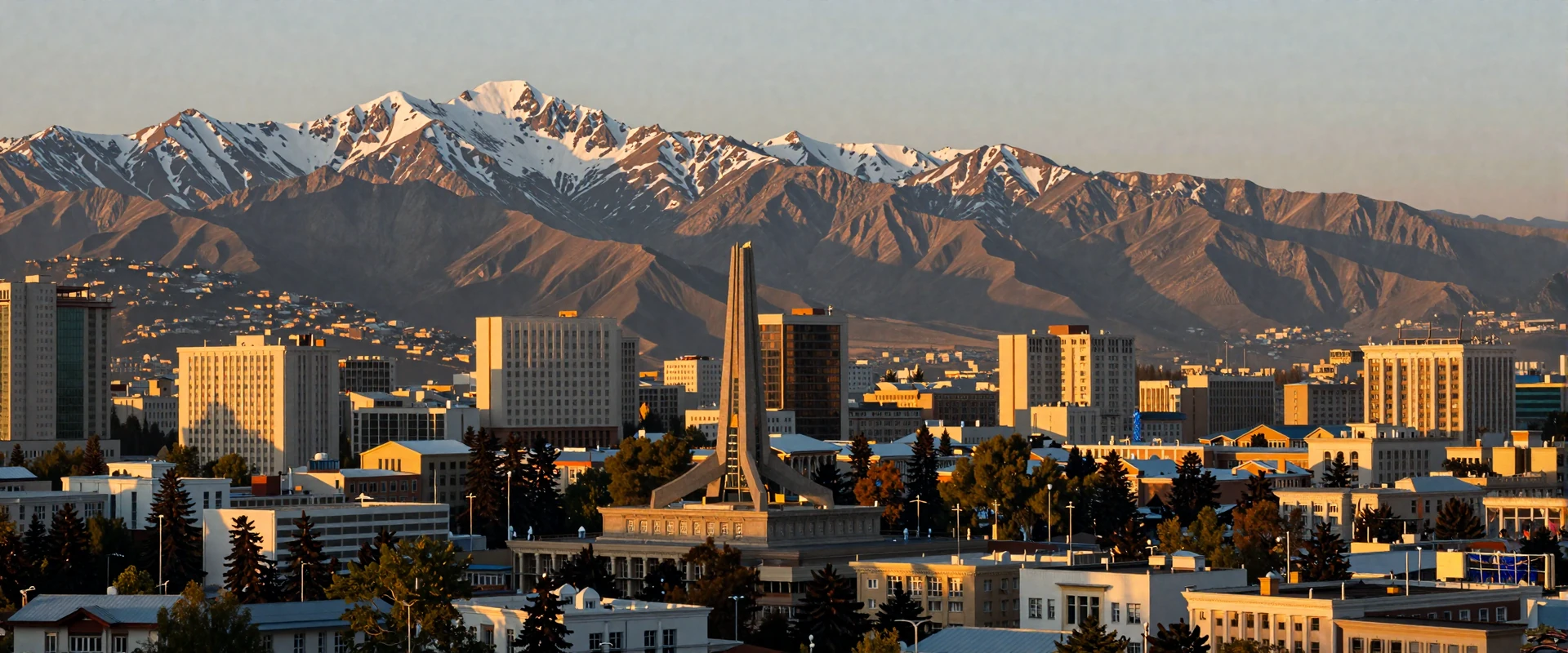 Dushanbe Tajikistan cityscape at golden hour with Fann Mountains and snow-capped peaks in the background