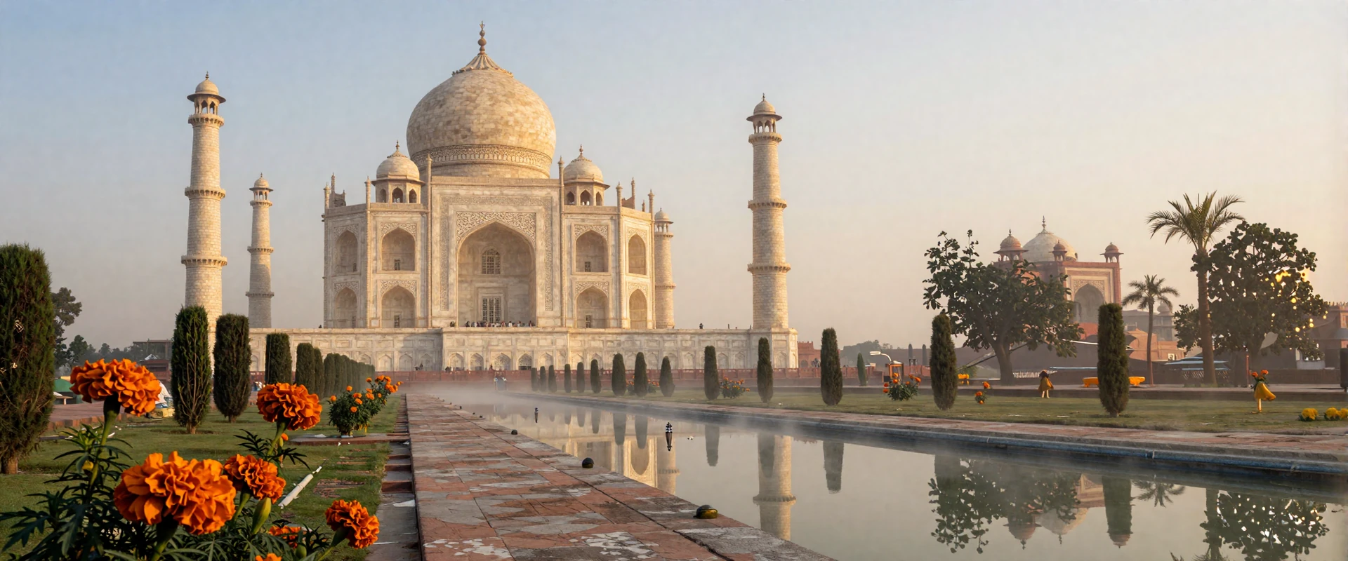 Taj Mahal at sunrise with golden light reflecting off marble and marigold gardens showcasing India romantic heritage
